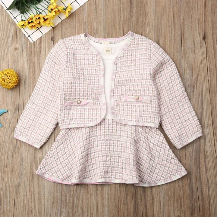 Pink and white plaid toddler girl dress with matching cropped jacket on wood background