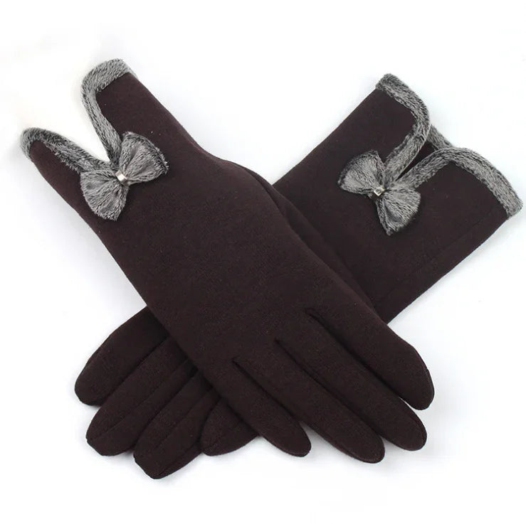 Black winter gloves with gray faux fur trim and decorative bow detail on white background
