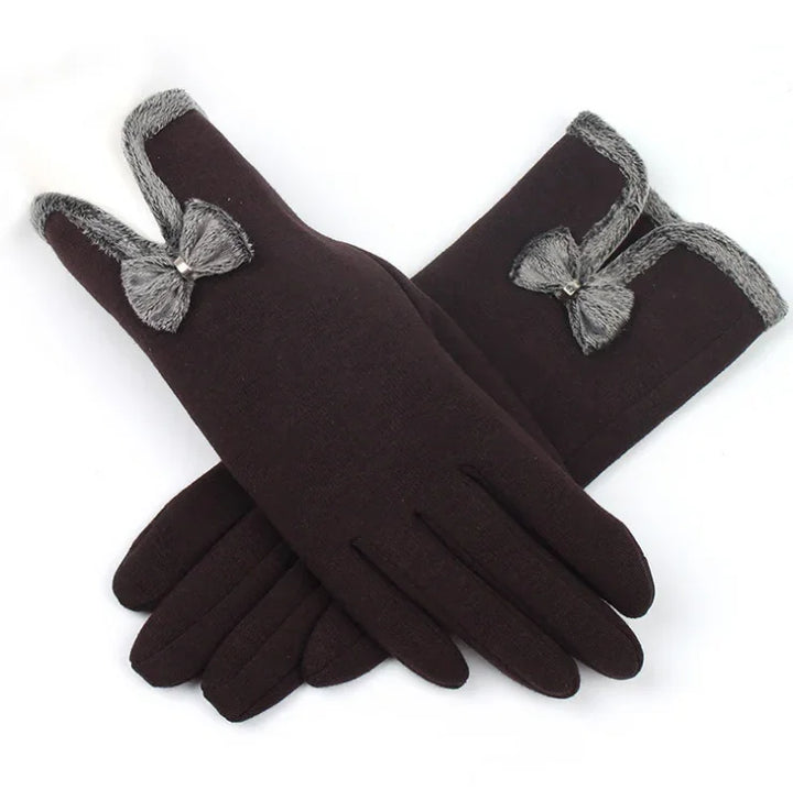 Black winter gloves with gray faux fur trim and decorative bow detail on white background