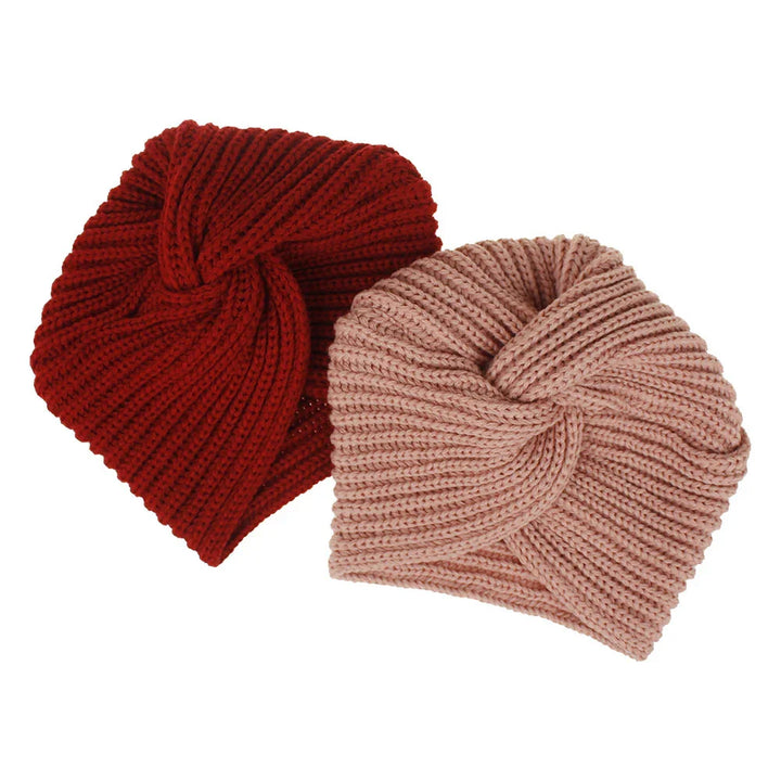 Two knitted turban-style headbands in red and light pink on white background