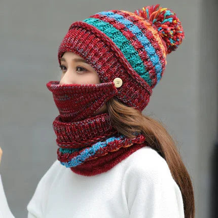 Woman wearing a multicolor knit winter hat with pom-pom and matching face cover scarf set
