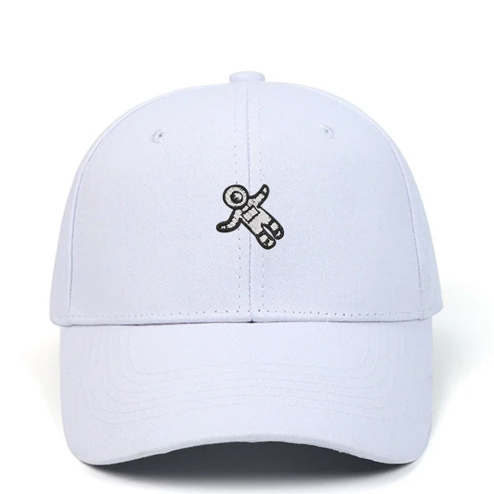 White baseball cap with a small black astronaut figure embroidered on the front