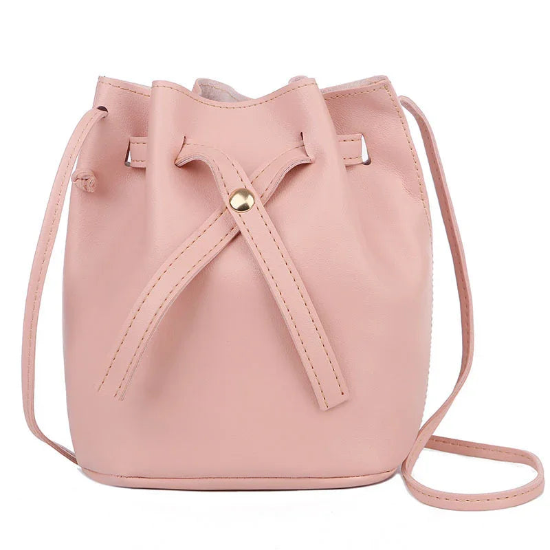 Blush pink leather bucket bag with drawstring closure and adjustable shoulder strap