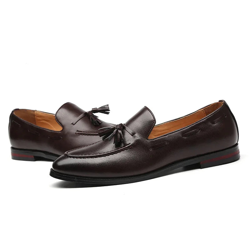 Dark brown leather men's tassel loafers with black soles and red accent heel detail