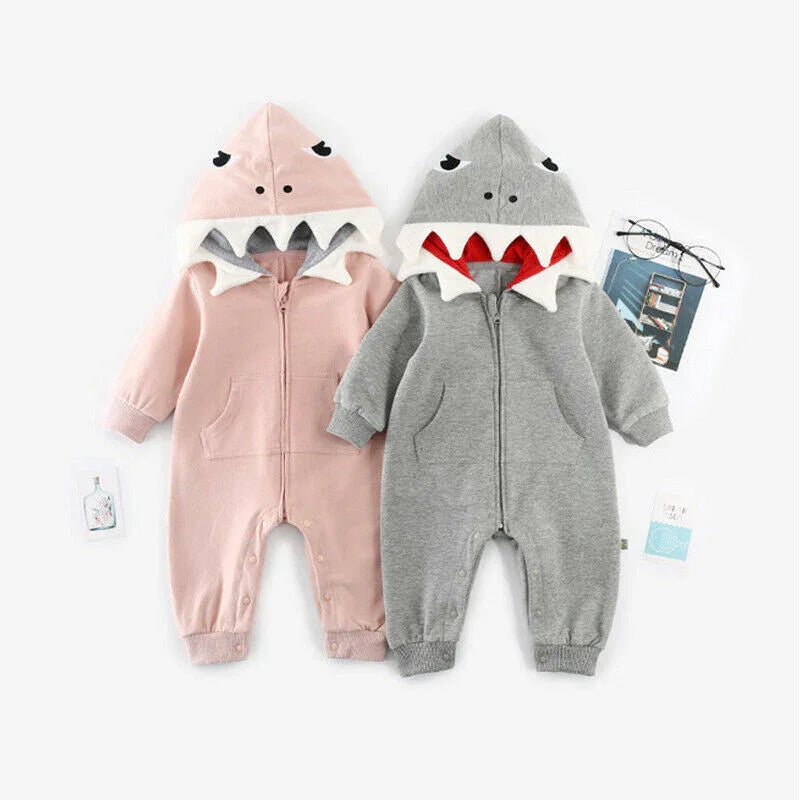 Two baby jumpsuits with shark-fin hoods in pink and gray, featuring front pockets and snap buttons