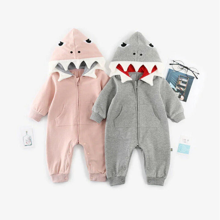 Two baby jumpsuits with shark-fin hoods in pink and gray, featuring front pockets and snap buttons