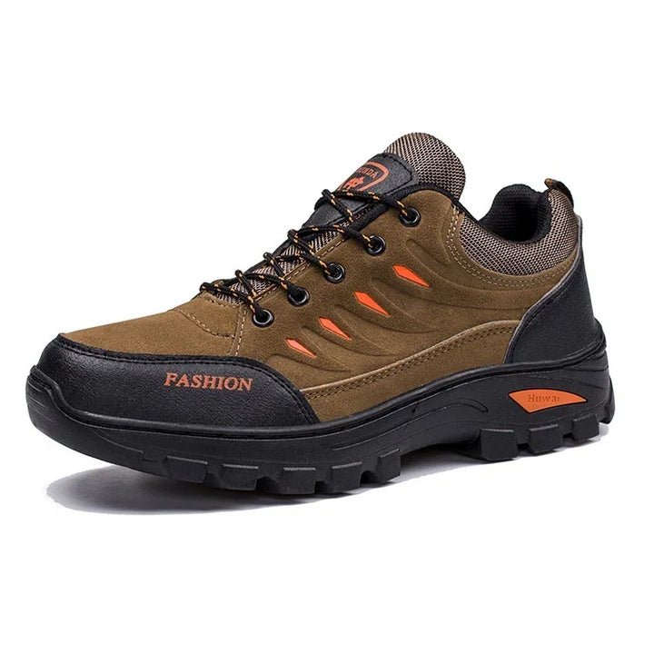 brown and black hiking shoe with orange accents, rugged sole, and fashion branding