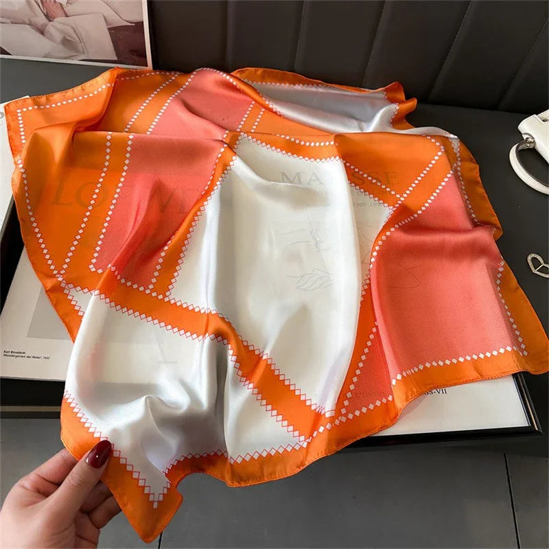 Orange and white checkered silk scarf with subtle logo detail on black surface