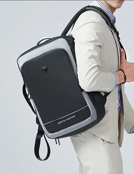 Man wearing a stylish black and gray Arctic Hunter backpack with a thumb up, dressed in a light beige suit