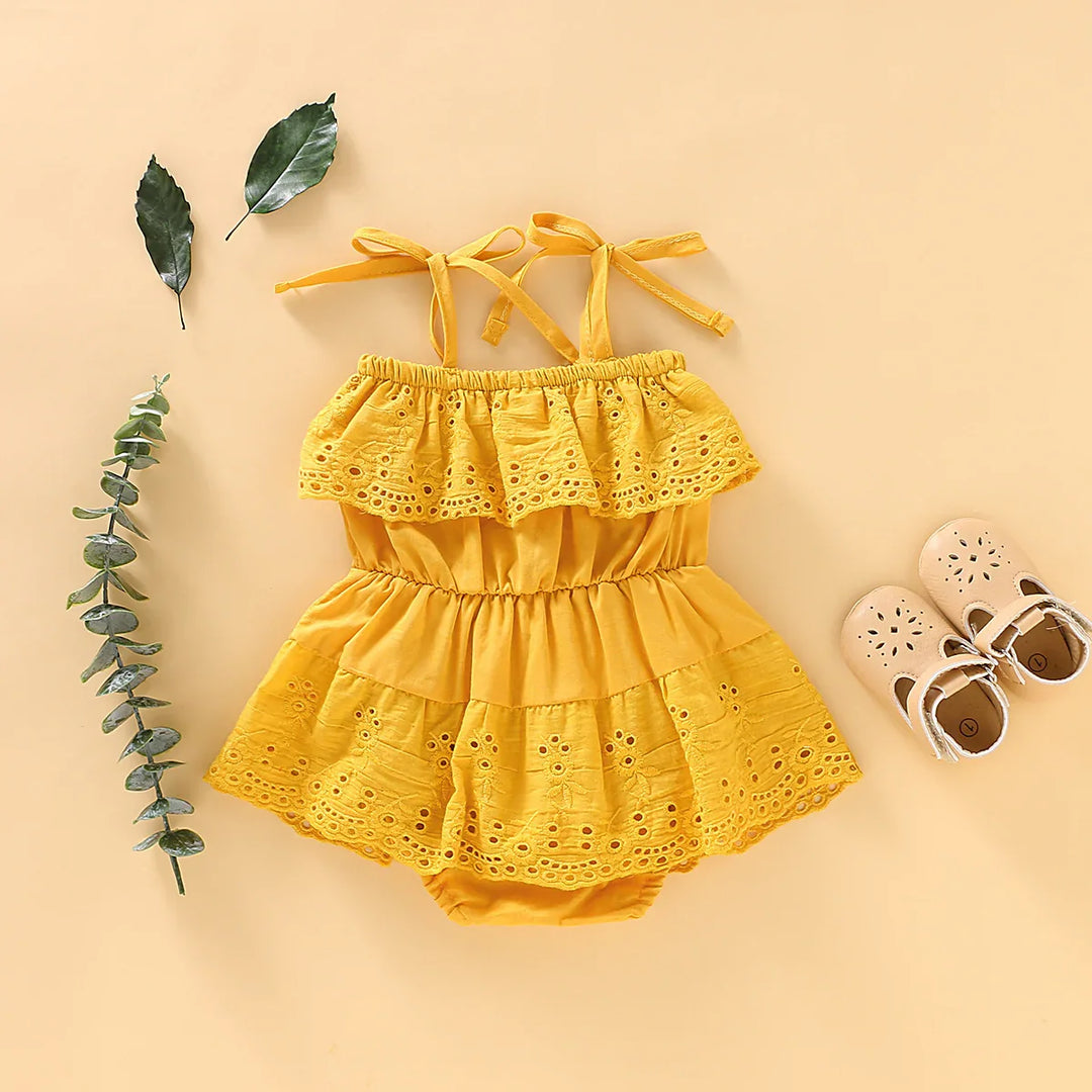 Yellow baby girl summer dress with eyelet lace and beige shoes on beige background