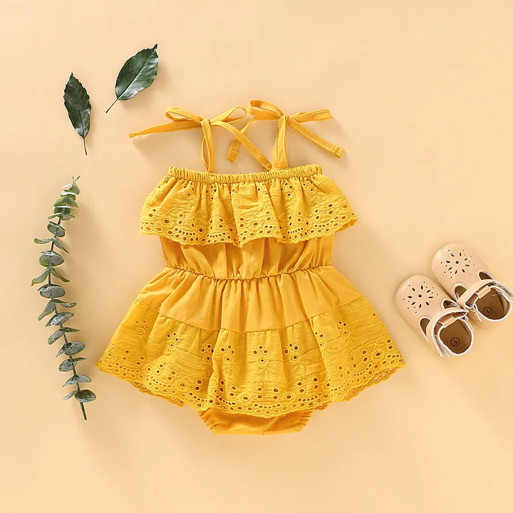 Yellow baby girl summer dress with eyelet lace and beige shoes on beige background