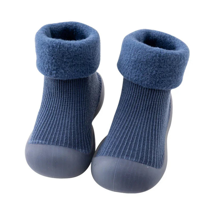 Pair of blue baby socks with fold-over fleece cuffs and rubber soles for indoor wear