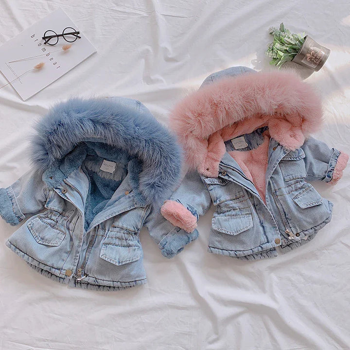 Two toddler denim jackets with fluffy fur-lined hoods in blue and pink on white background