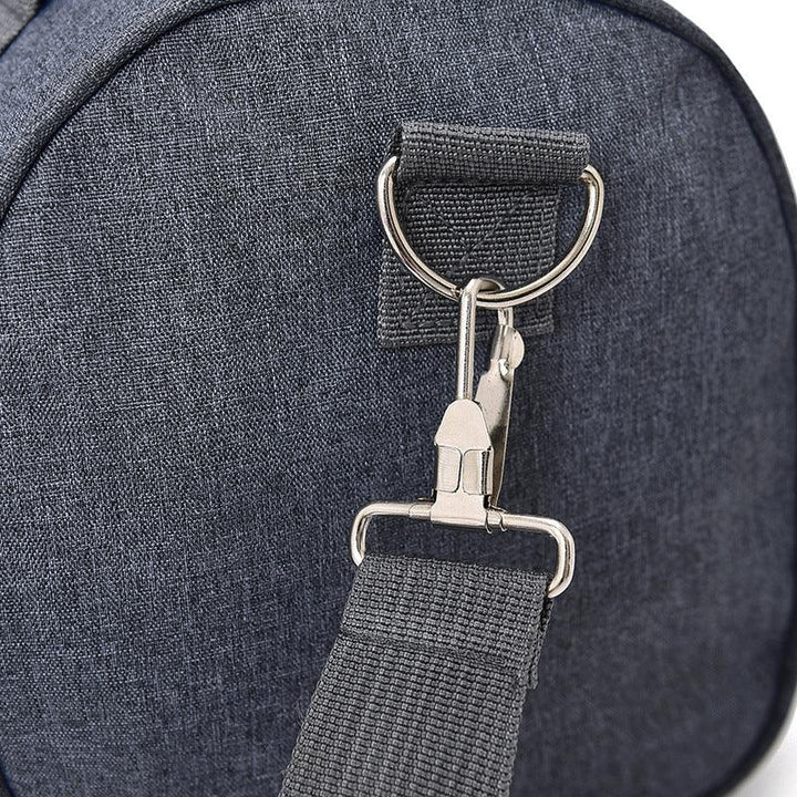 Close-up of dark gray fabric backpack with metal swivel clasp and strap attachment