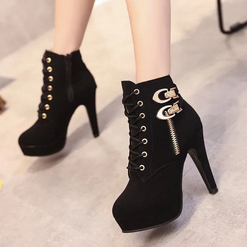 Black high heel platform ankle boots with gold eyelets, side zipper, and double buckle details