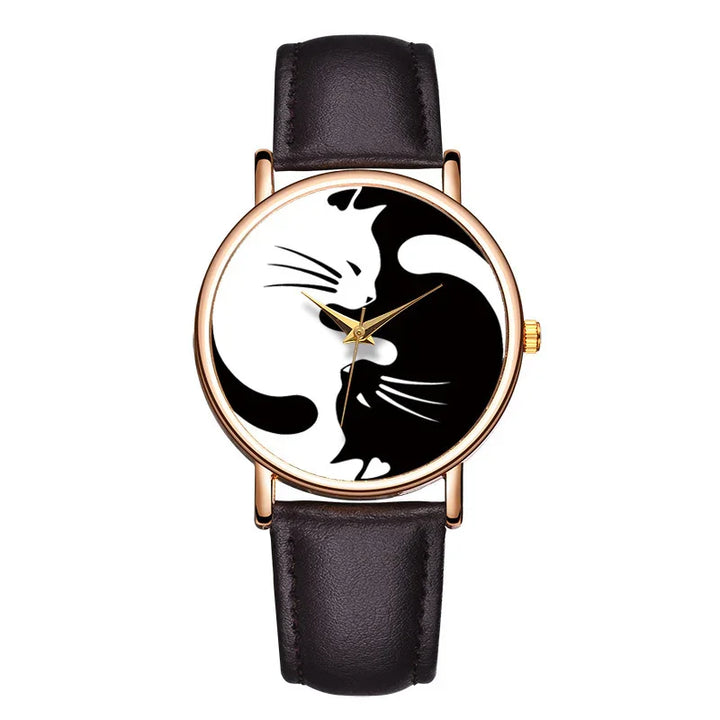 Wristwatch with black leather strap and gold case featuring yin-yang cats design on dial