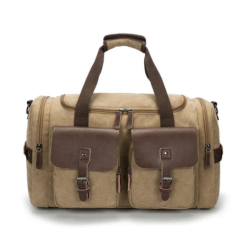 Beige canvas duffle bag with brown leather straps and front pockets, double zipper closure