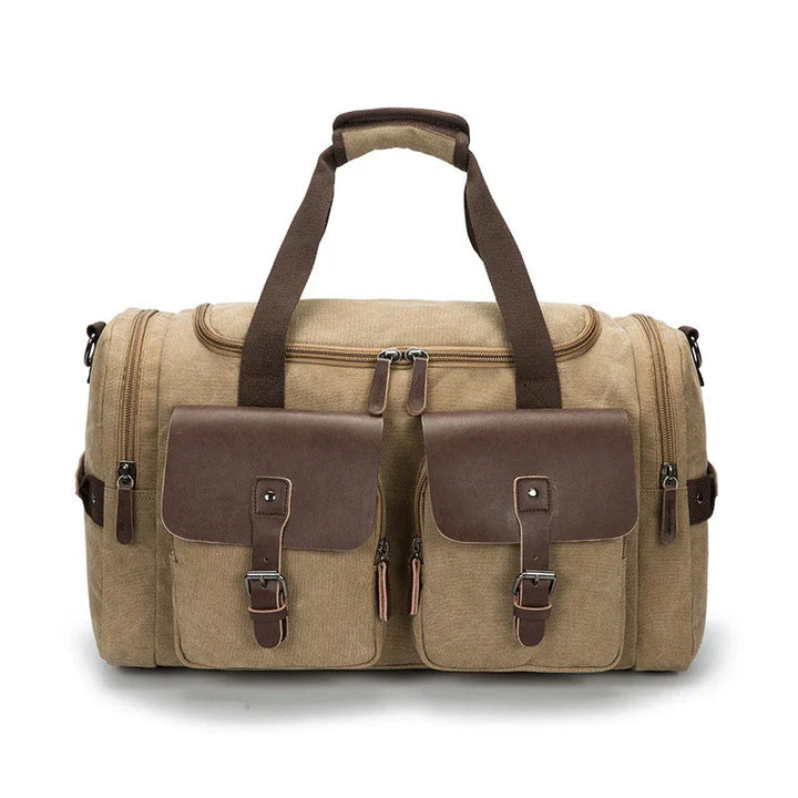 Beige canvas duffle bag with brown leather straps and front pockets, double zipper closure