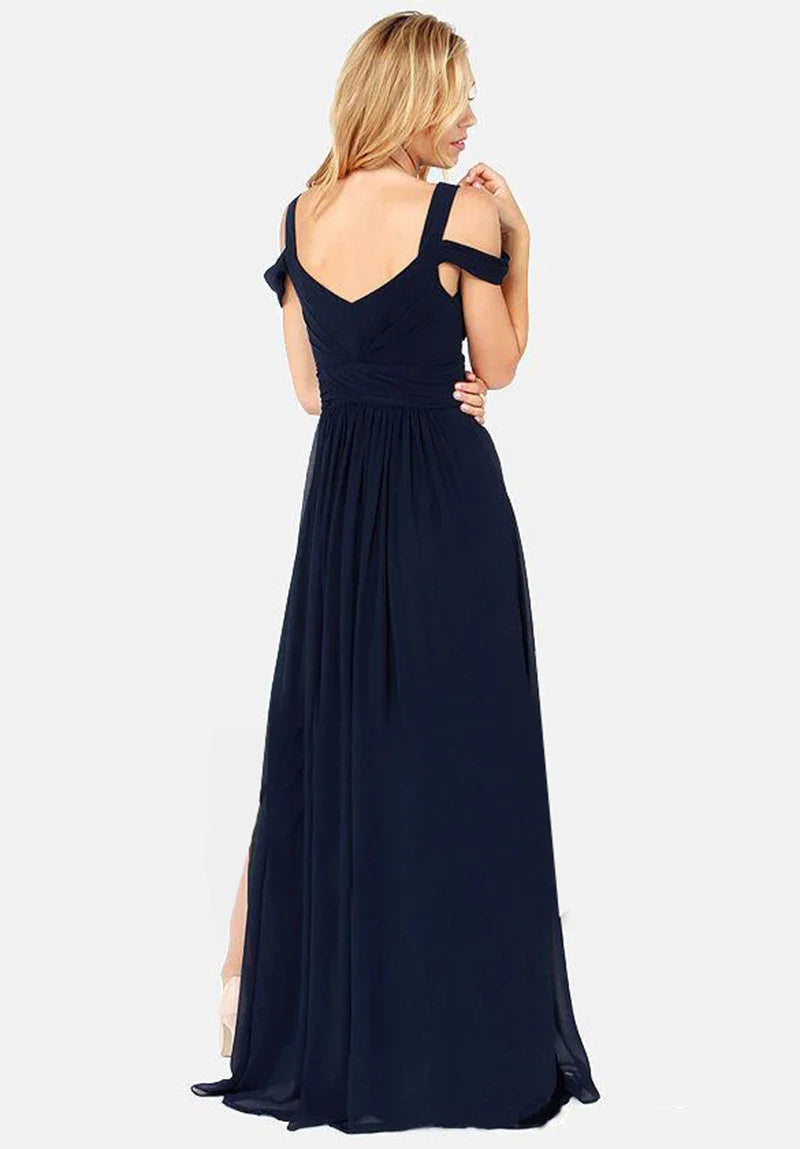 Blonde woman wearing a navy blue off-shoulder evening gown with a V-back and flowing skirt