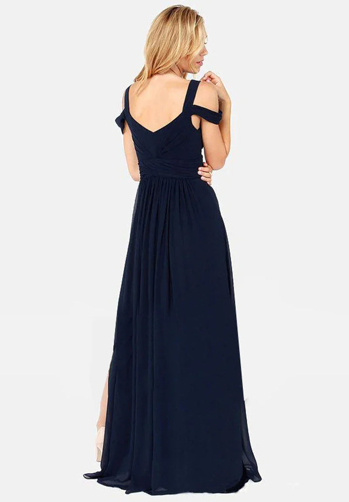 Blonde woman wearing a navy blue off-shoulder evening gown with a V-back and flowing skirt
