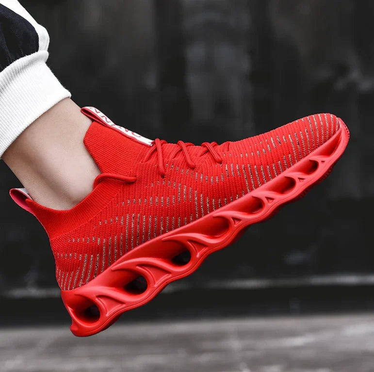 Red athletic sneaker with breathable knit upper and hollow cushioned sole worn with black and white pants
