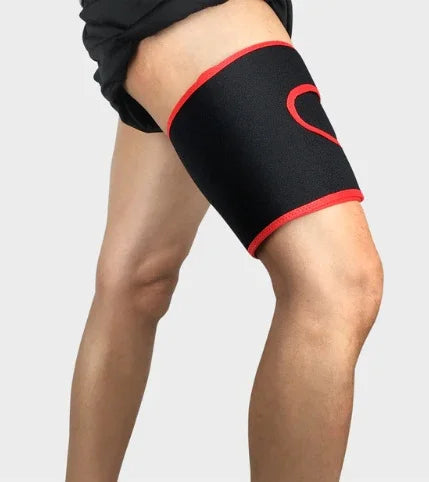 Person wearing black and red thigh compression sleeve for muscle support