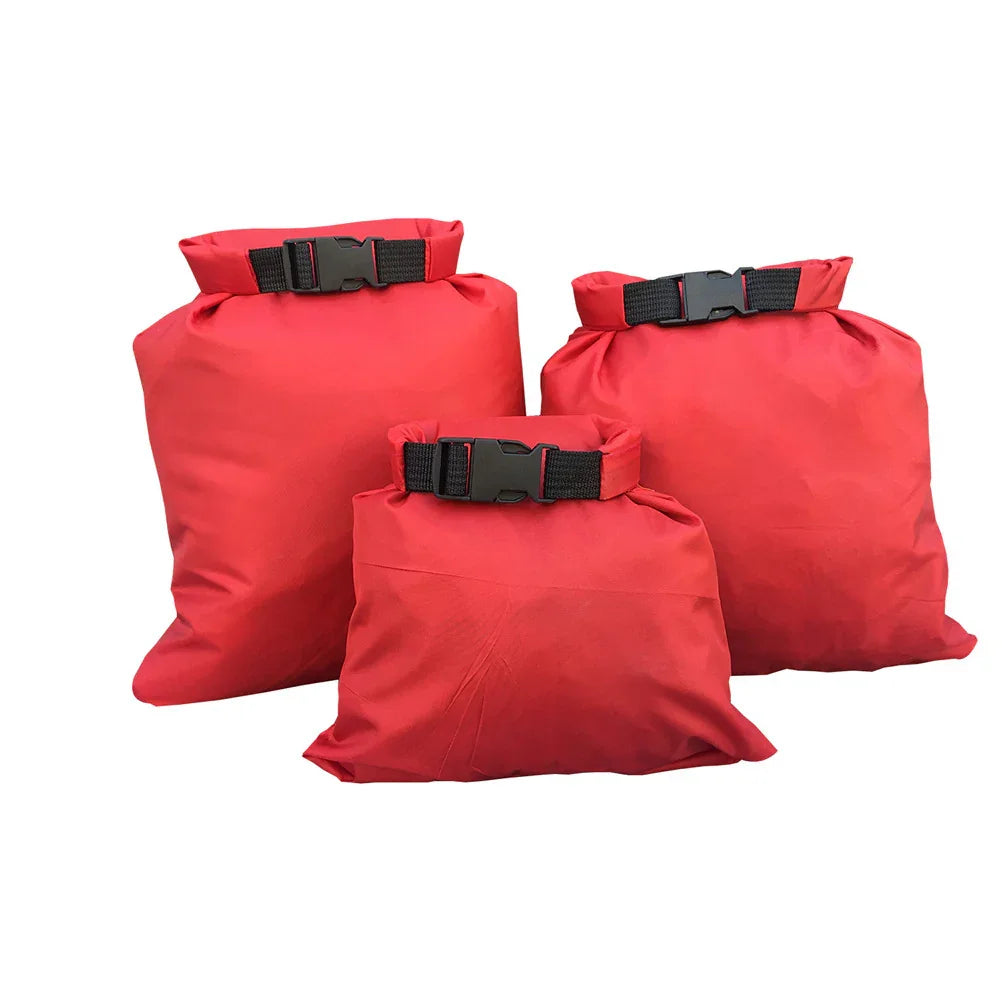 Three red waterproof dry bags with black buckle closures on a white background