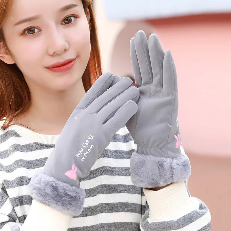 Woman wearing grey winter gloves with faux fur cuffs and pink bunny design, striped sweater