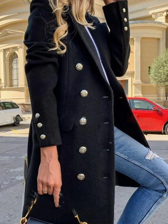 woman wearing black double-breasted coat with silver buttons and ripped blue jeans holding black handbag outdoors