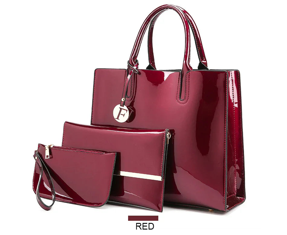 Glossy red patent leather handbag set with three pieces including tote, clutch, and wristlet