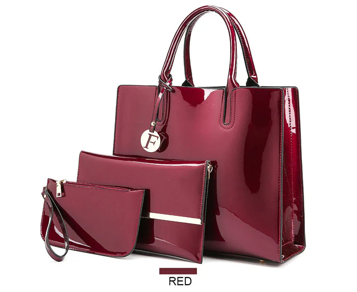 Glossy red patent leather handbag set with three pieces including tote, clutch, and wristlet