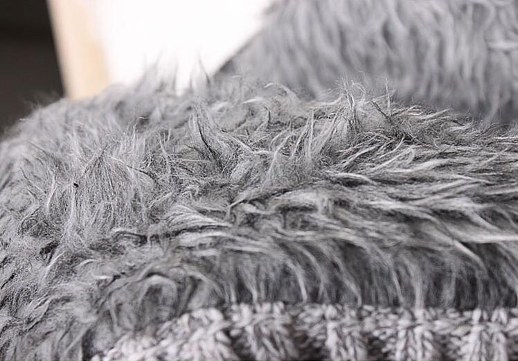 Close-up of soft, fluffy gray faux fur fabric with textured knit material underneath