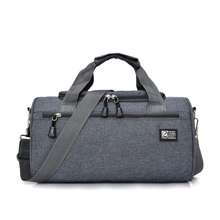 Gray fabric duffle bag with dual handles, adjustable shoulder strap, and front zipper pocket