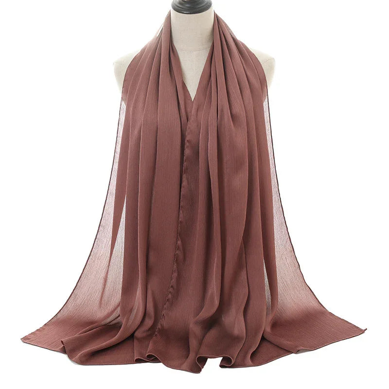 Soft brown pleated chiffon scarf displayed on white mannequin bust