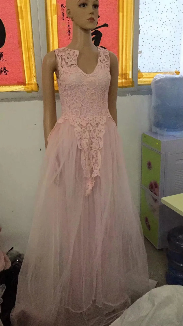 Mannequin wearing a sleeveless pink lace top dress with layered tulle skirt in a room