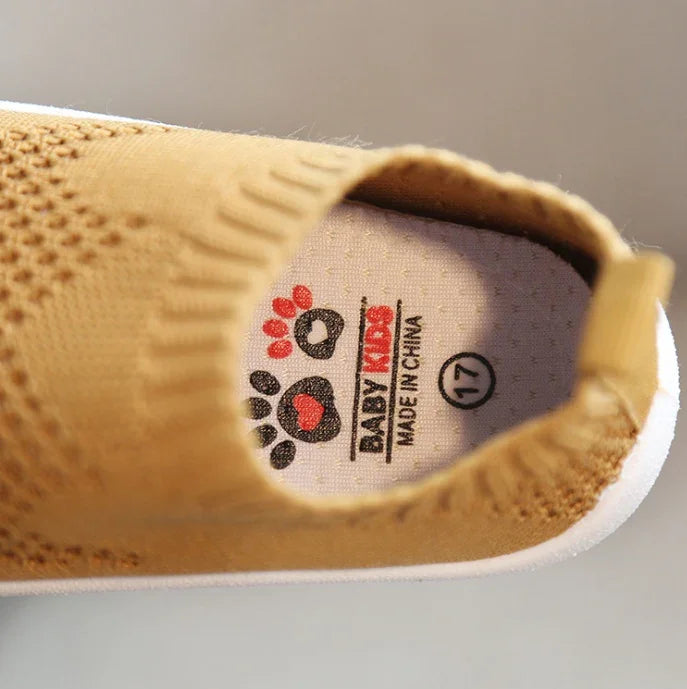Close-up of inside label on brown knitted baby shoe with paw prints, size 17, made in China