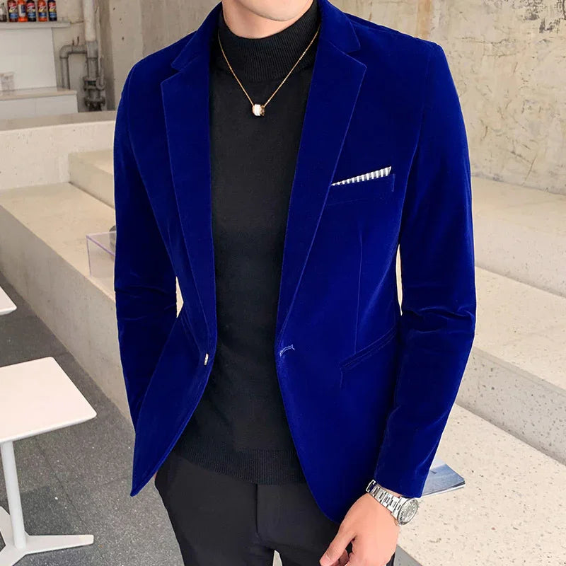 Man wearing royal blue velvet blazer with black turtleneck and silver watch in modern cafe
