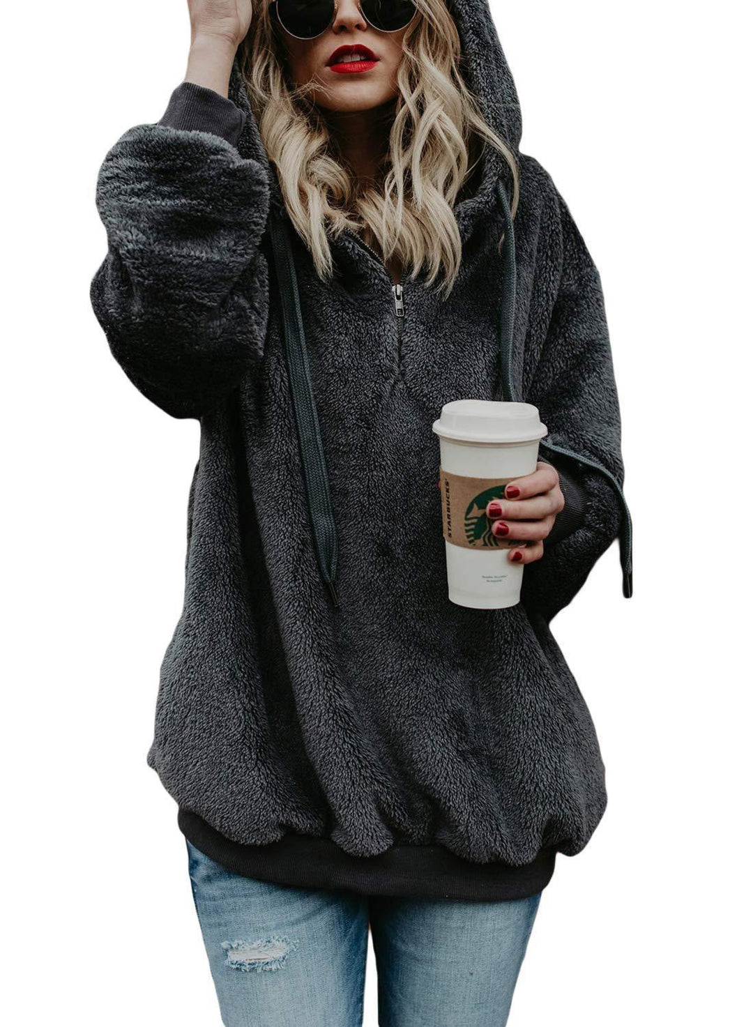 Woman in black fuzzy hoodie holding a Starbucks cup, wearing sunglasses and red lipstick