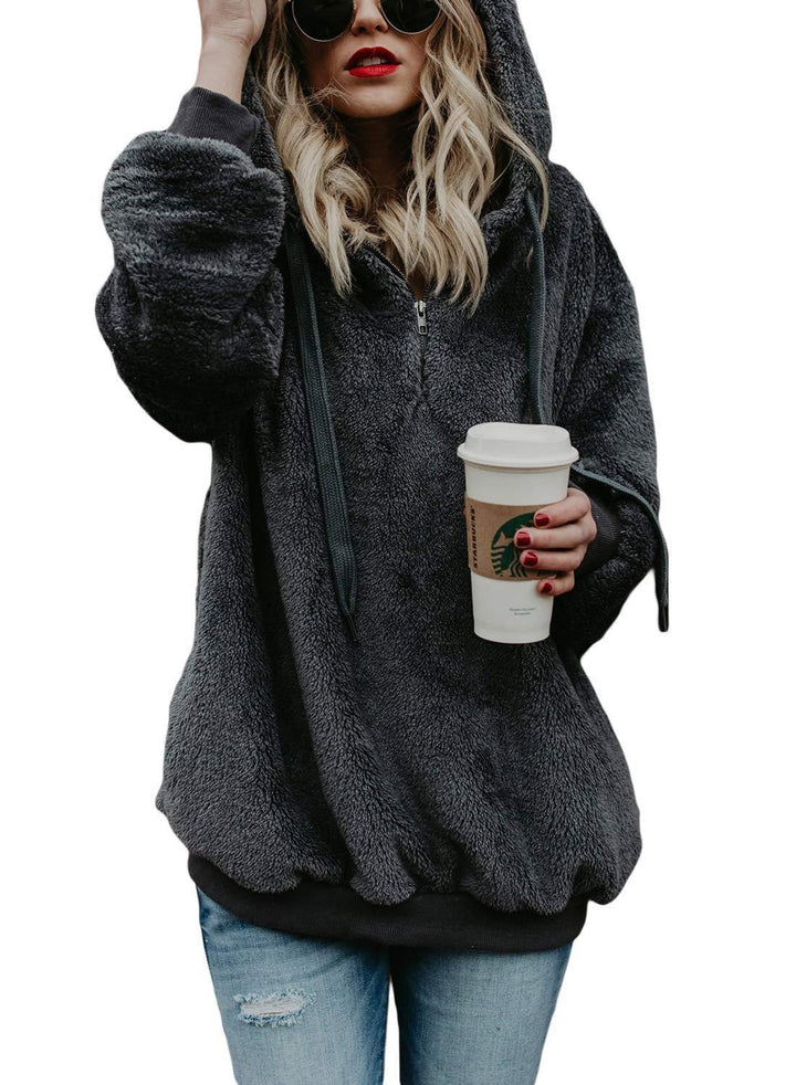 Woman in black fuzzy hoodie holding a Starbucks cup, wearing sunglasses and red lipstick