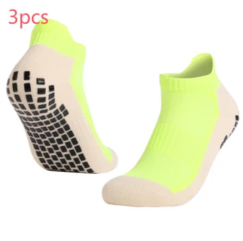 Pair of neon yellow and beige non-slip grip ankle socks with black rubber sole pads