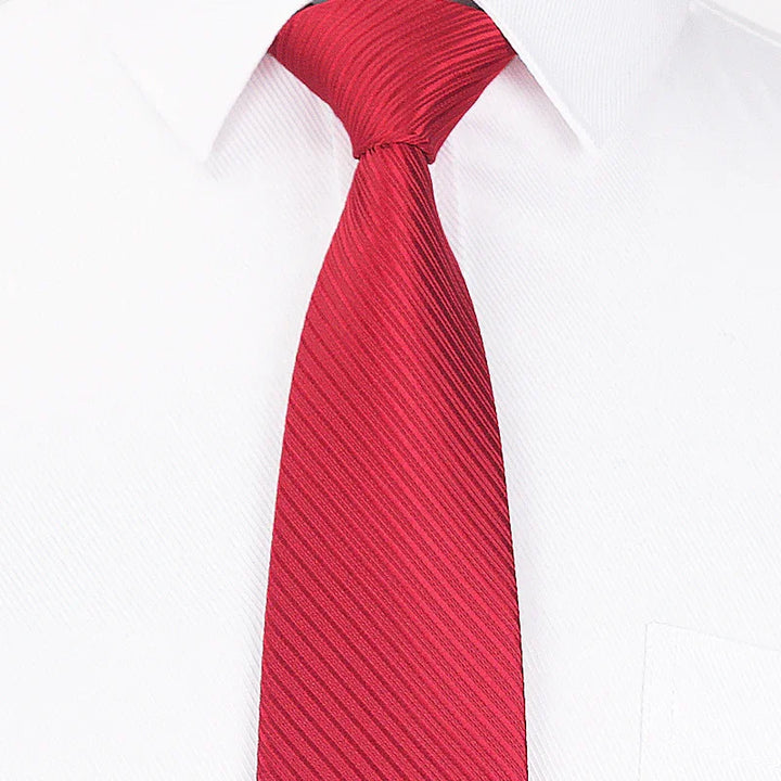Close-up of a red striped necktie on a white dress shirt with a pocket
