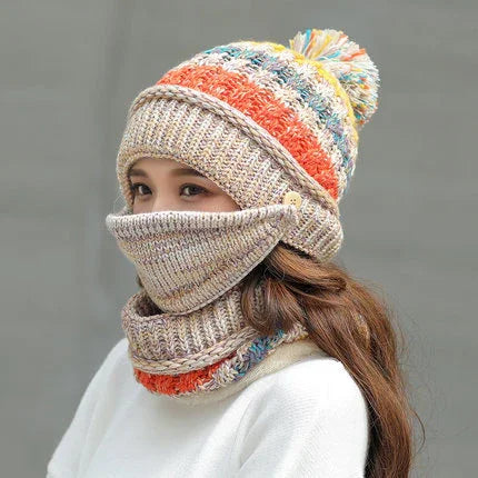 Woman wearing colorful knit winter hat with pom-pom and matching face cover and neck warmer