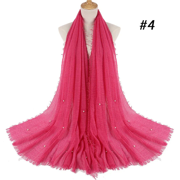 Bright pink lightweight scarf with delicate pearl embellishments displayed on mannequin