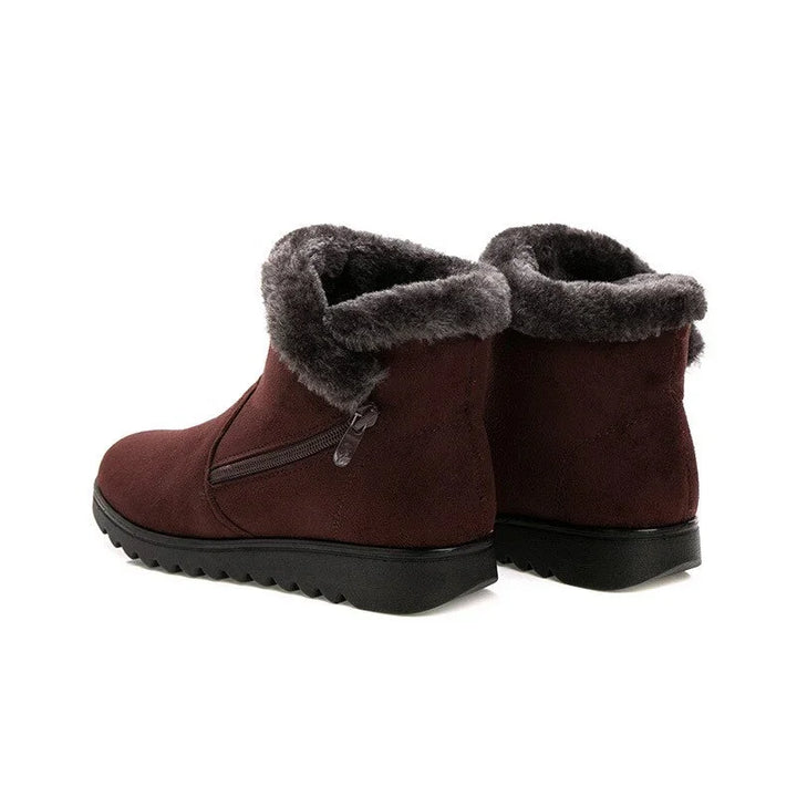 Pair of dark brown suede winter ankle boots with black soles and plush gray fur lining
