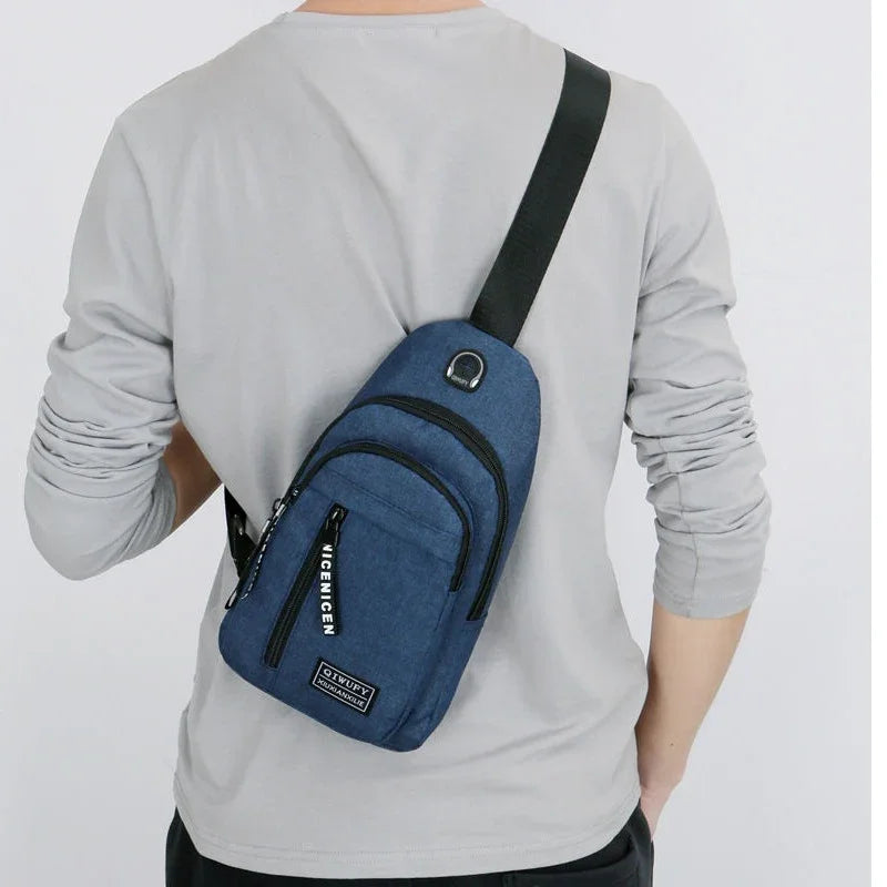 Man wearing a blue crossbody sling bag with black strap and multiple zippered compartments