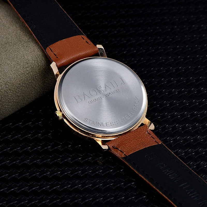 Close-up of Baosaili quartz watch with stainless steel back and brown leather strap on black textured surface
