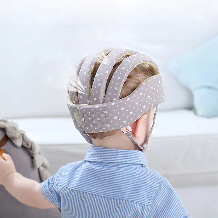 Child wearing a soft padded star-patterned helmet indoors for head protection