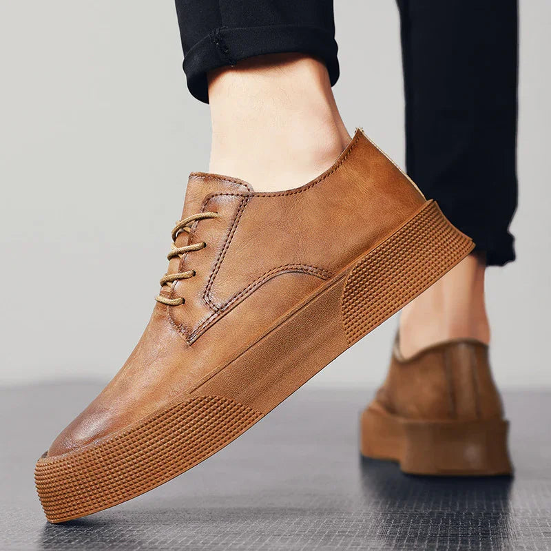 Brown leather casual sneakers with thick textured soles worn with black pants