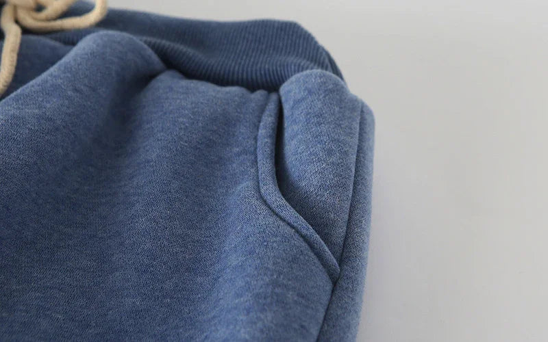 Close-up of blue cotton fleece jogger pants pocket with waistband and drawstring