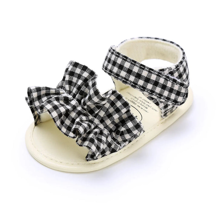 Black and white gingham baby sandal with ruffle front and ankle strap on white background